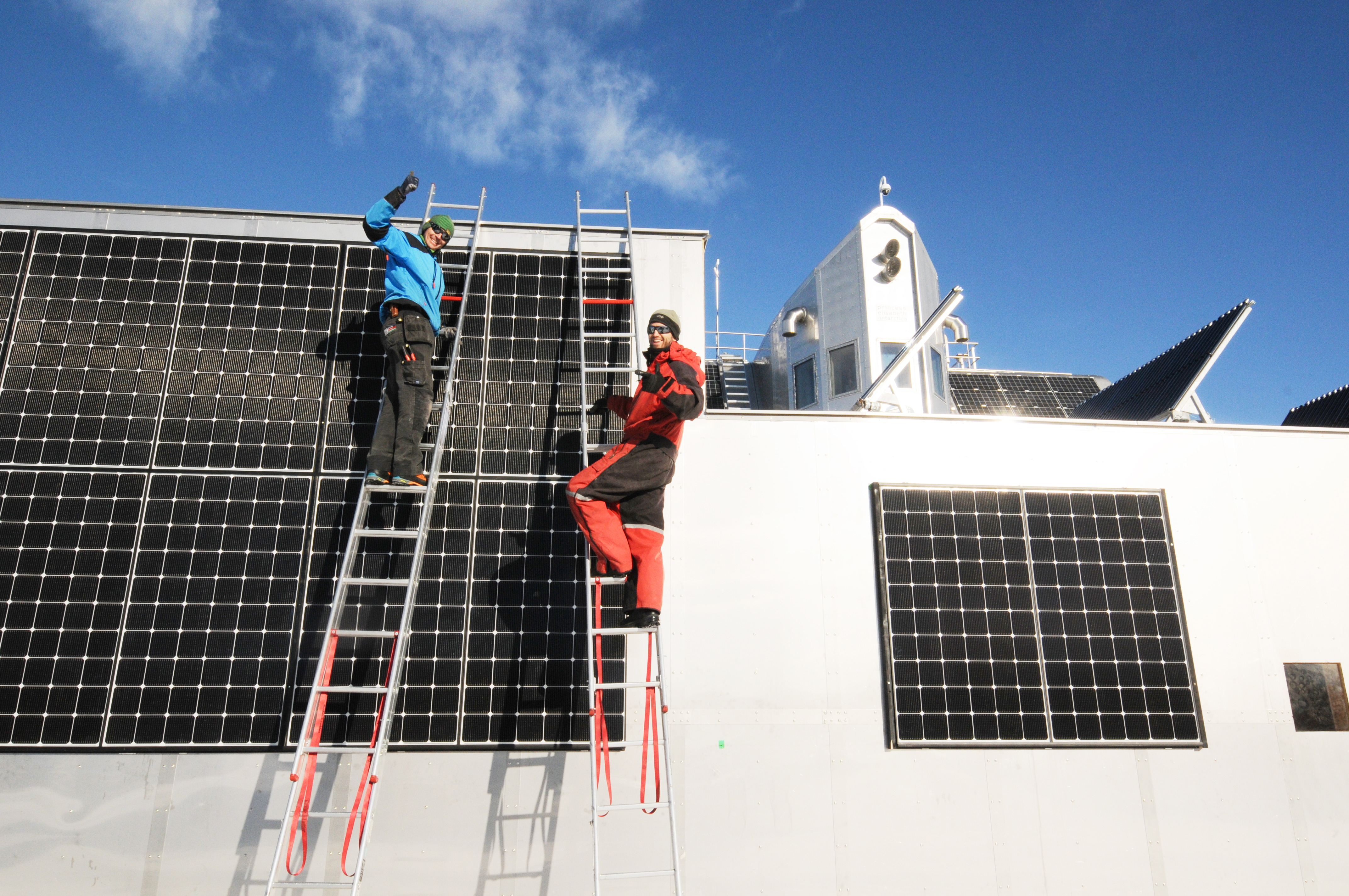Guus and Johan wiring new solar panels on PEA's new garage