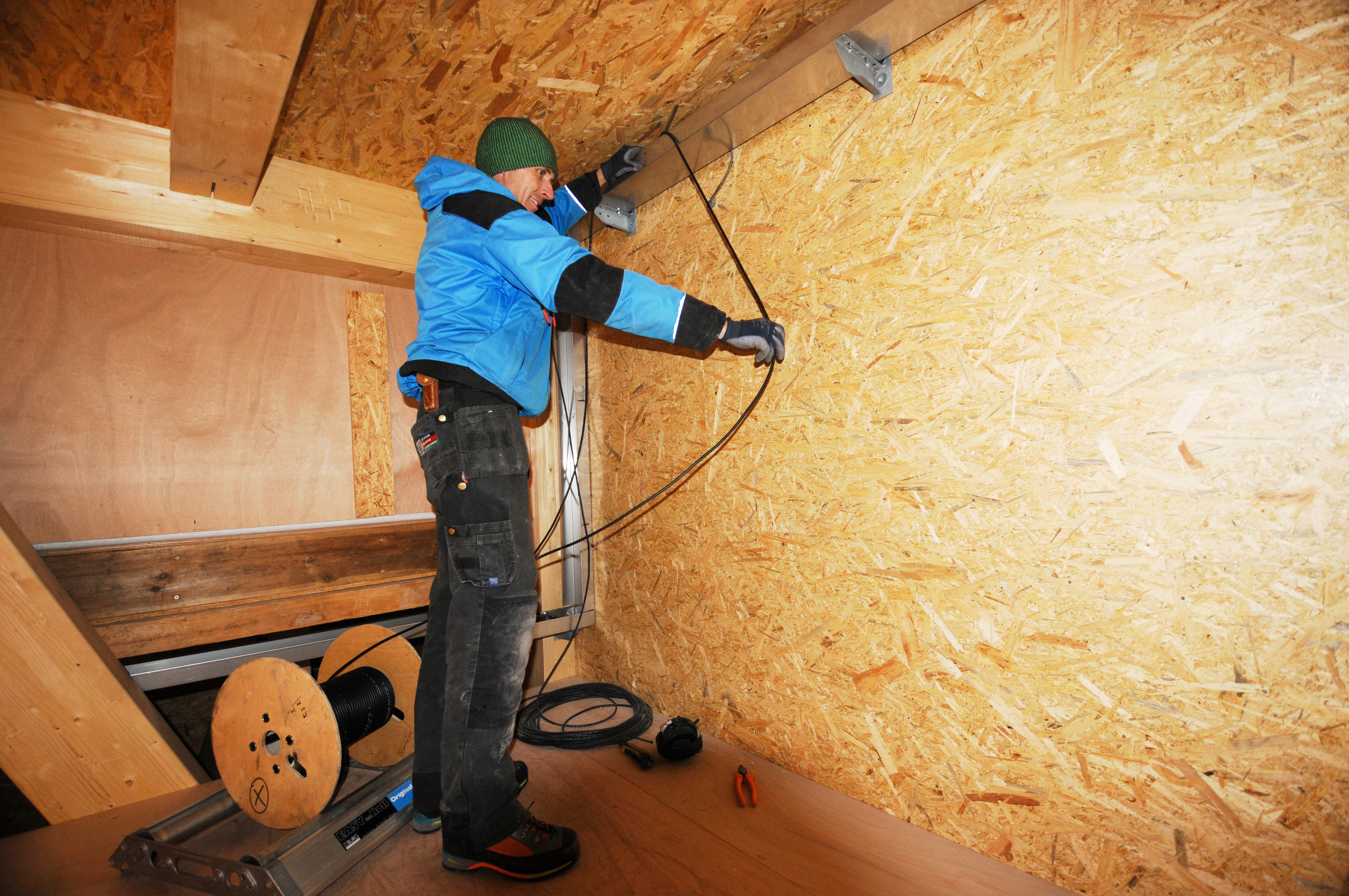 Johan installing cables for new solar panels on garage