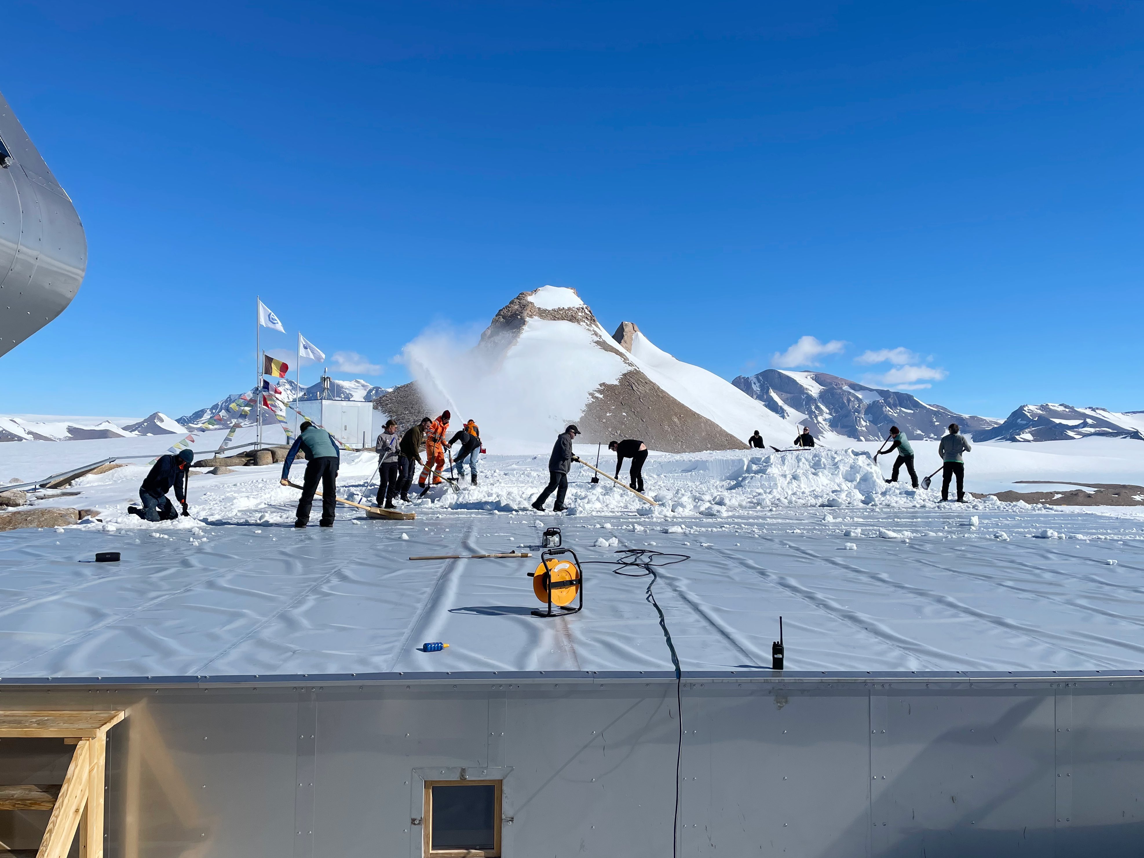 Clearing snow from the roof of PEA's annexes on a warm day to avoid meltwater pooling