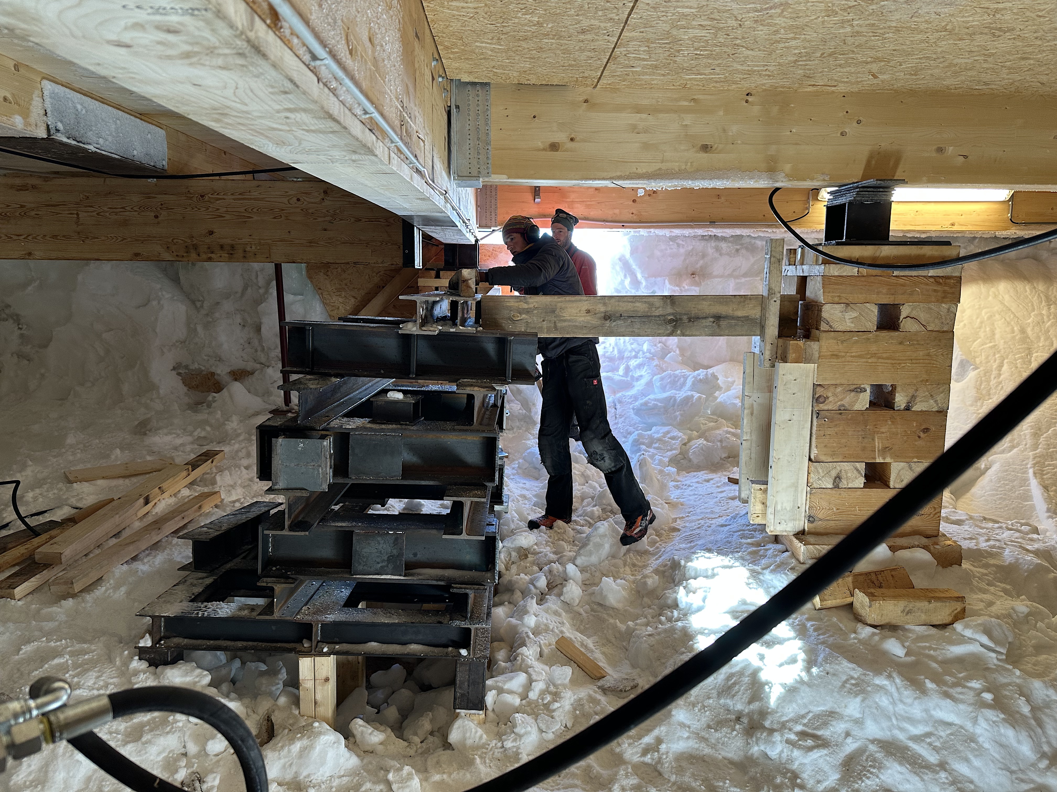 The carpenters prepare to install a steel I-beam underneath PEA's annex