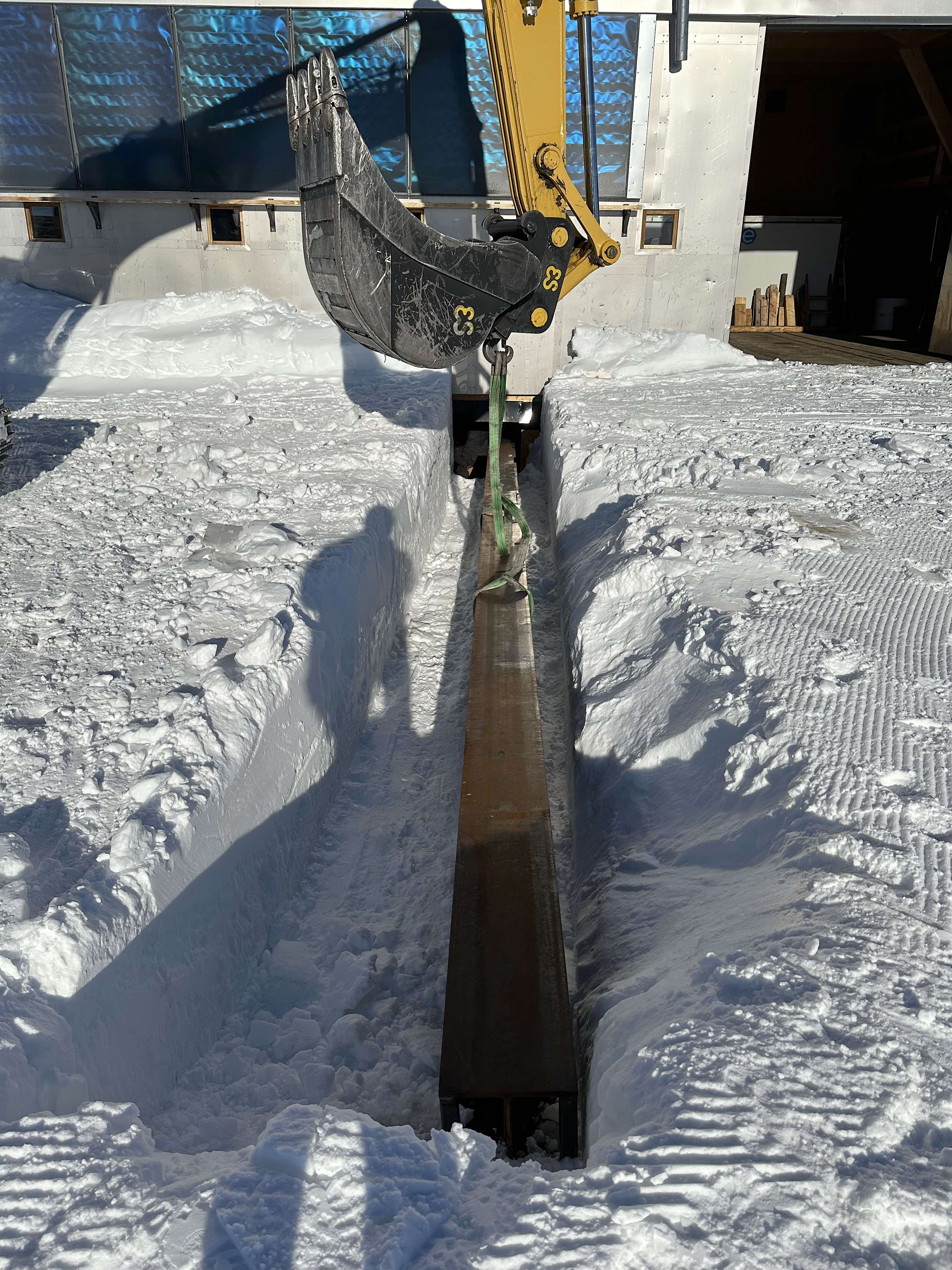 Lowering a steel I-beam beneath PEA's annex
