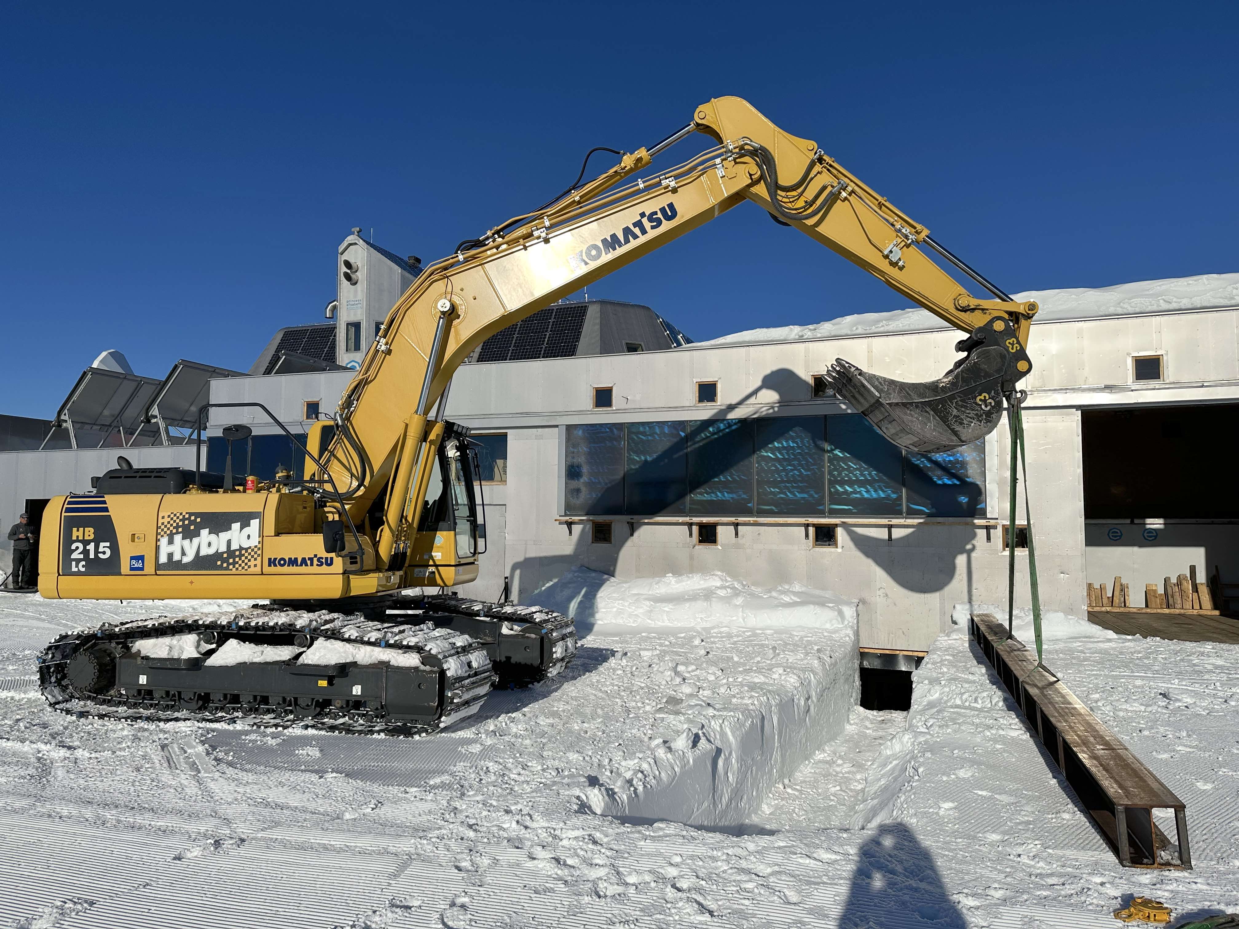 Using the hybrid Komatsu earth mover to position a steel I-beam