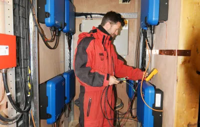 engineer Guus Luppens cables inverters to solar panels at PEA