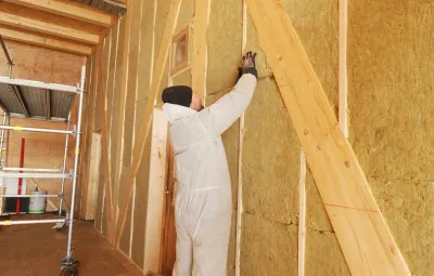 Thomas the carpenter finalises the insulation in the walls of PEA's new garage