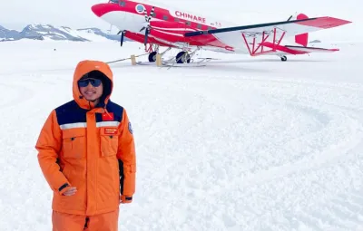 Kai Lu CHINARE Scientist in front of Snow Eagle aircraft at PEA