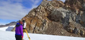Kate using a terrestrial laser scanner to accurately map the mountains